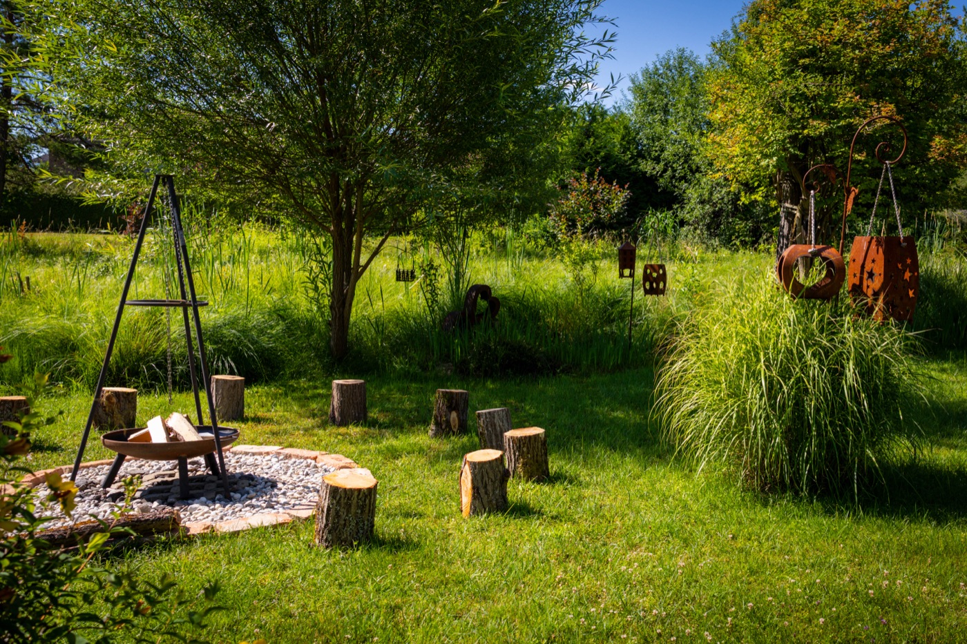 Garten mit Feuerschale und Sitzstämmen – Ort für individuelle Kurse und Workshops